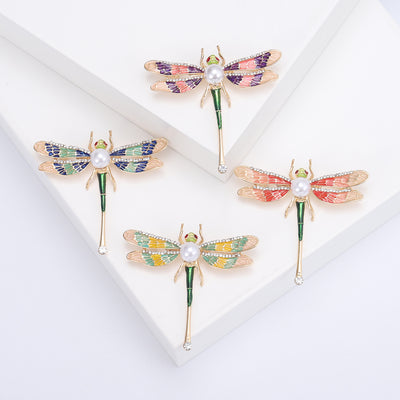 Front view of patterned enamel dragonfly brooch with pearl accent