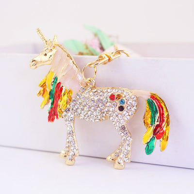Close view of a pale pink unicorn with clear stones and red, green, and yellow accents.