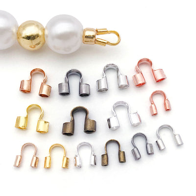 Metallic connector clasp jewelry findings arranged on a light background