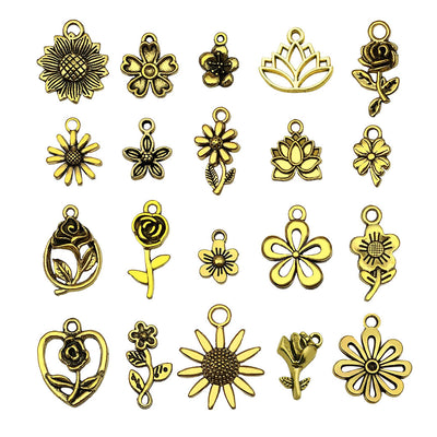 Matte gold-tone sun and sunflower charms arranged on a light background