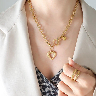 Woman in blazer wearing gold open heart toggle necklace with cable chain