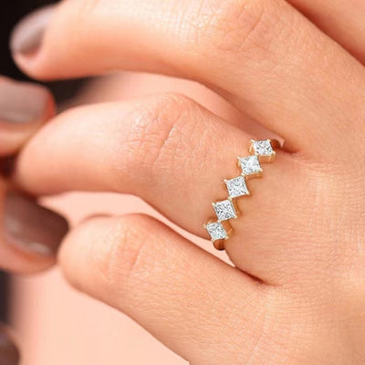 Gold five princess cut CZ stones ring worn on finger