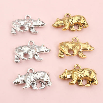 Hand held view of the dimensional walking bear charms showing the front shape and finish