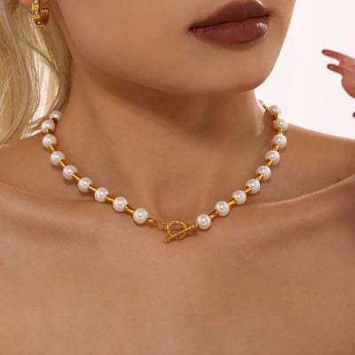 Model wearing white pearl and gold bamboo spacer necklace with OT clasp