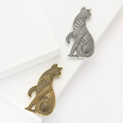 Gold and silver geometric textured sitting cat brooches on white