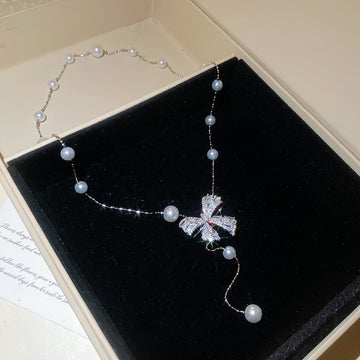 Silver Tone Bow And Pearl Station Necklace With Decorative Accents