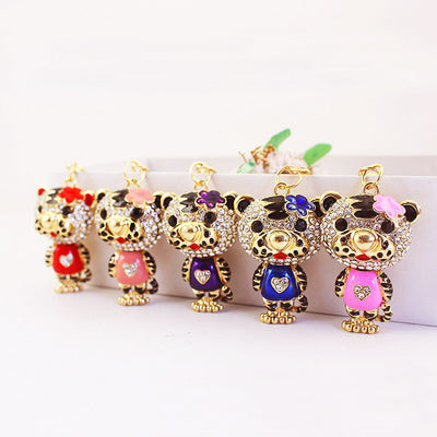 Five gold-tone tiger figures in red, peach, purple, blue and pink stand in a row.