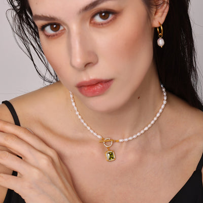 Model wearing olive zircon pearl necklace and pearl huggie earrings