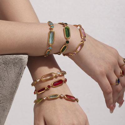 Stack of multicolor oval glass stone bracelets on wrists