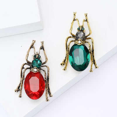 Green and red antique gold beetle brooches side by side