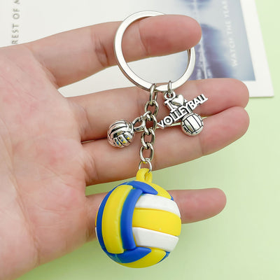 Image 1 showing a hand holding a volleyball ball keychain.