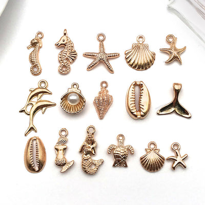 Orange starfish and mermaid charms arranged on a light background