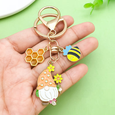 Image 1 showing a hand holding a keychain with some charms.