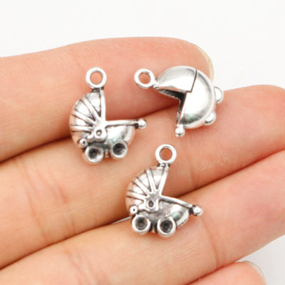 Hand held view of the detailed baby stroller charms showing the front shape and finish