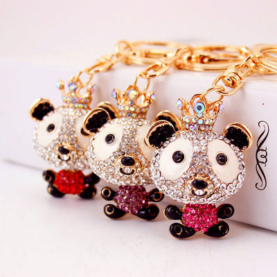 Three crowned panda keychains display hot pink, purple, and red rhinestone bodies.