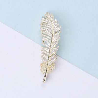 Gold pave crystal feather brooch front on pastel blocks