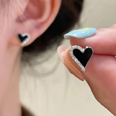 Black heart CZ-border stud worn on ear and matching stud held in hand