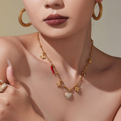 Model wearing gold bead chain necklace with zircon heart and red chili