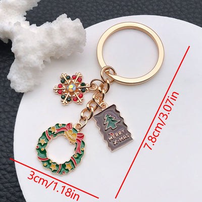Front product photo of wreath snowflake and christmas tree enamel charm keychain showing the pictured design arrangement