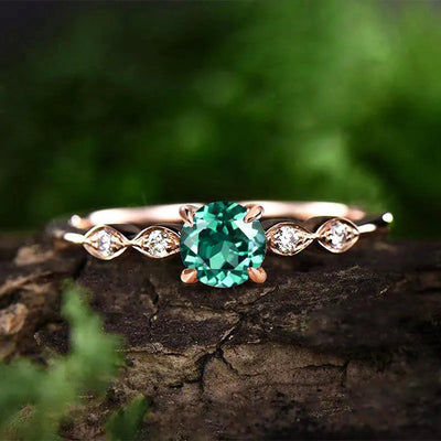 Rose gold green round stone ring with marquise accents on bark