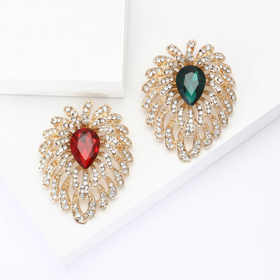 Front view of gold tone radiating burst with a large colored teardrop center