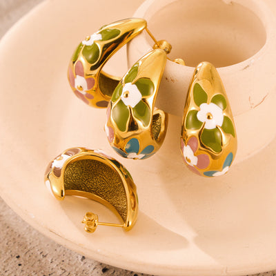 Gold floral enamel chunky hoop studs on ceramic display