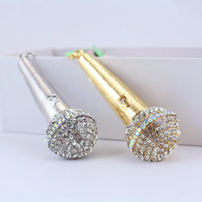Gold-tone and silver-tone microphone ornaments displayed together with rhinestone-covered heads.