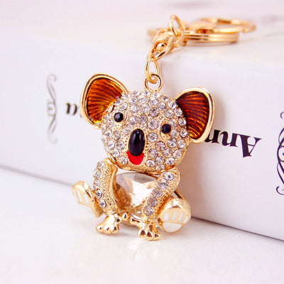Close-up of a seated gold-tone koala keychain with clear rhinestones and orange ears.