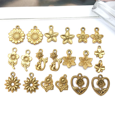 Gold-tone sunflower and cherry blossom charms arranged on a light background