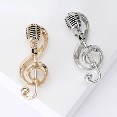 Gold and silver treble clef microphone brooches side by side