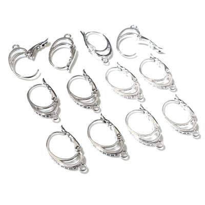 Overview of oval silver-tone leverback findings with small bottom loops on a light background