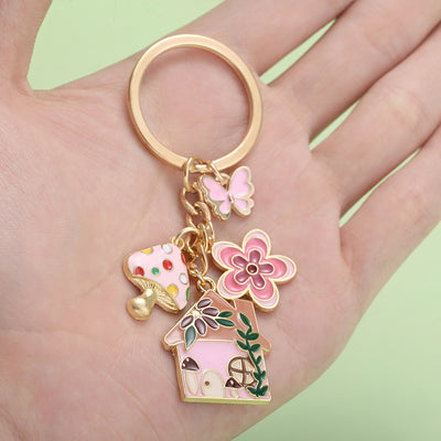 Image 1 showing a person holding a keychain with flowers and birds.