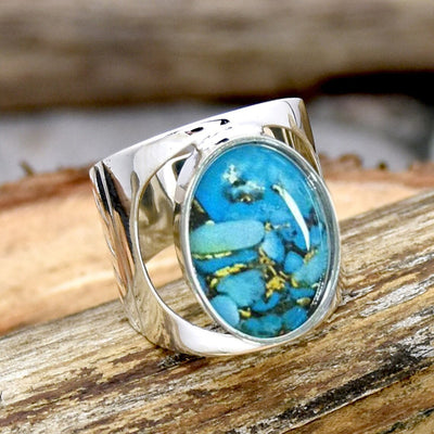 Angled silver blue oval cabochon openwork ring on wood
