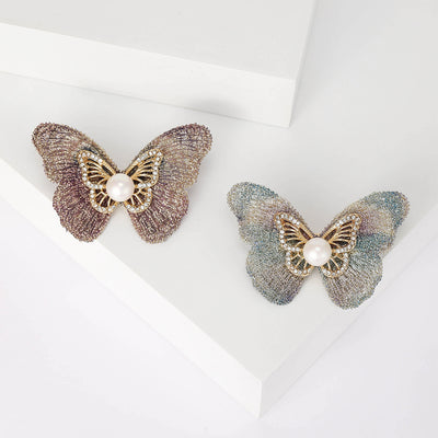 Front view of airy fabric wing butterfly with an openwork center and pearl accent