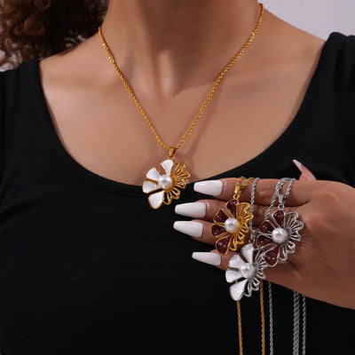 Model wearing gold white flower pearl necklace, holding three more