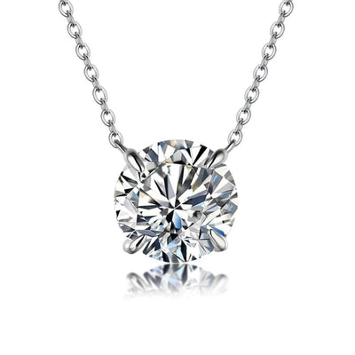 Silver round four-prong CZ solitaire pendant on white with reflection
