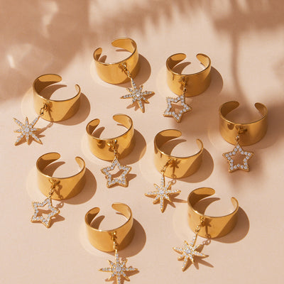 Group of gold open cuff rings with five-point and starburst zircon charms