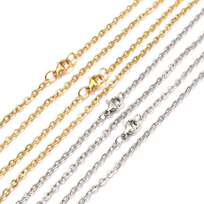 Overview of fine link chains with lobster clasps in gold and silver tones on a light background