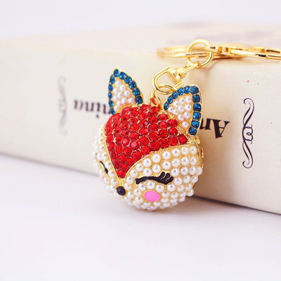 Close view of a red stone fox face with blue-edged ears and white bead details.