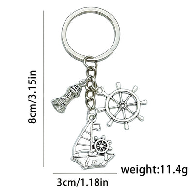 Measurement graphic showing a silver-tone lighthouse, ship wheel and sailboat keychain at 8 cm by 3 cm and 11.4 g.