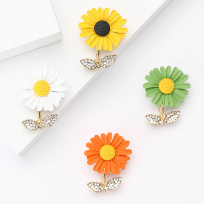 Front view of single daisy bloom above two clear crystal leaves
