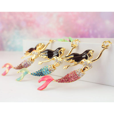 Three gold-tone mermaid charms with pink, blue, and purple rhinestone tails.