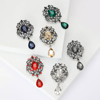 Front view of the ornate crystal brooch with teardrop dangle decorative clothing pin on a white background