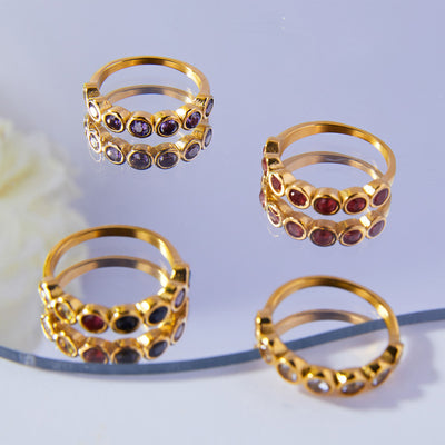 Four gold five-stone zircon band rings white purple red multicolor on mirror