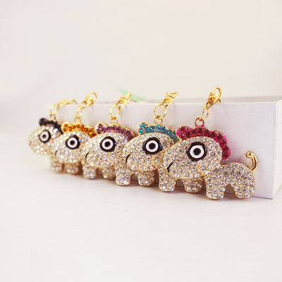 Five one-eyed dog charms with pink, blue, purple, orange, and black top stones are arranged in a row.