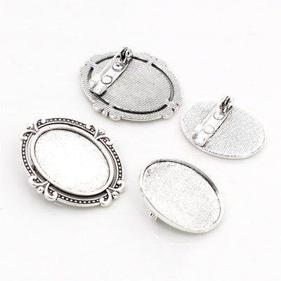 Oval cabochon brooch tray fitted with a pin back in a group view on a white background