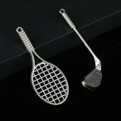 Silver-tone tennis racket charm beside a golf club charm on a black surface