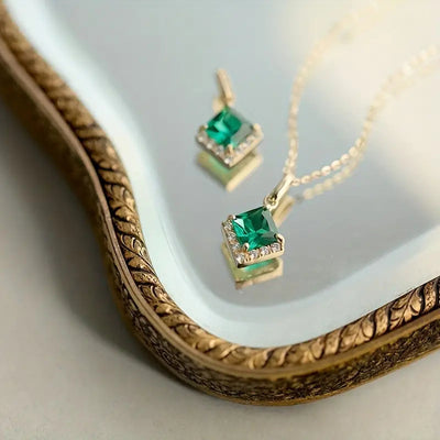 Gold square green stone pendant on ornate tray with loose charm