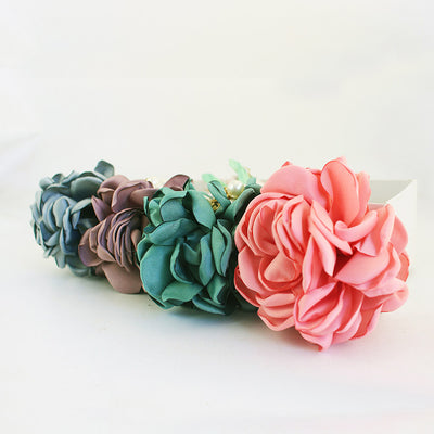 Four fabric rose clusters in gray, coffee brown, green, and pink arranged in a row.