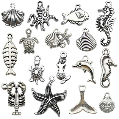 Metallic seahorse and starfish charms arranged on a light background